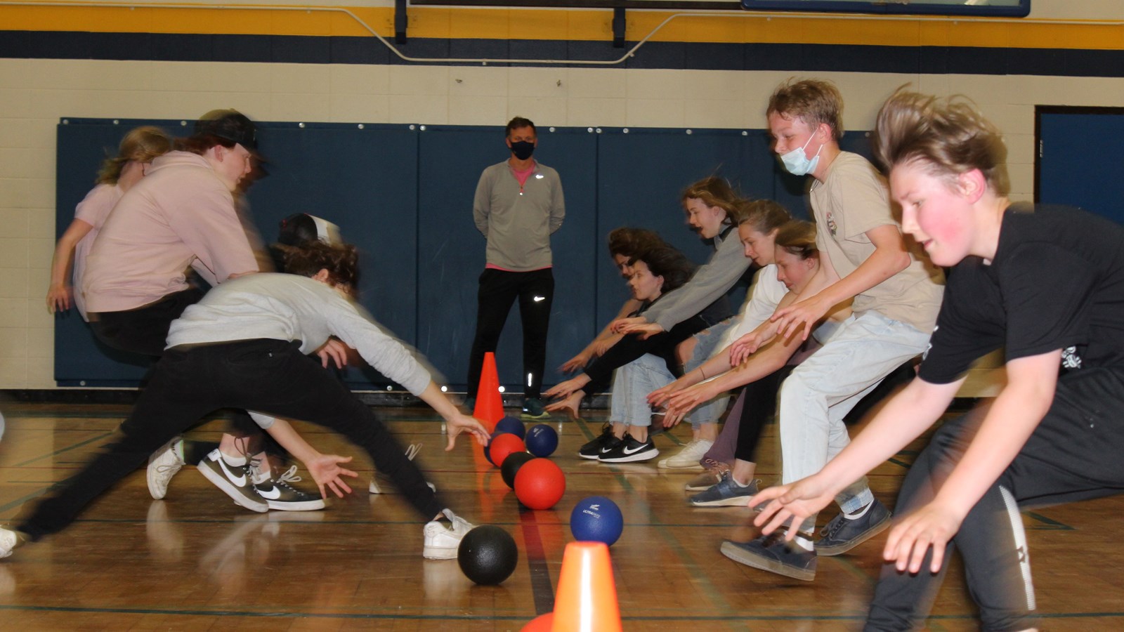 Students race to grab balls from the dodgeball starting line.