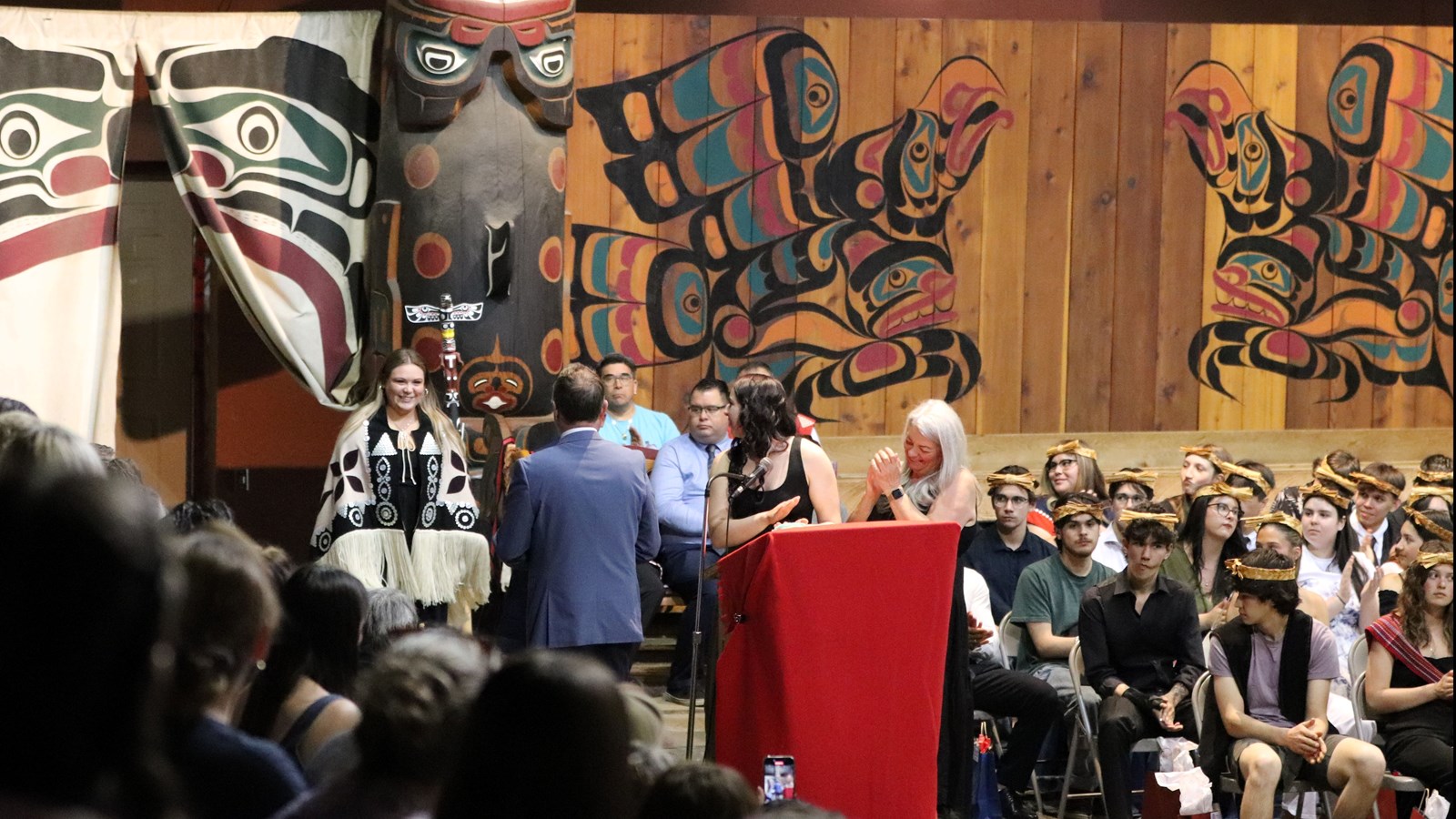 One of the evening's many graduates from Carihi Secondary being applauded into the Big House.